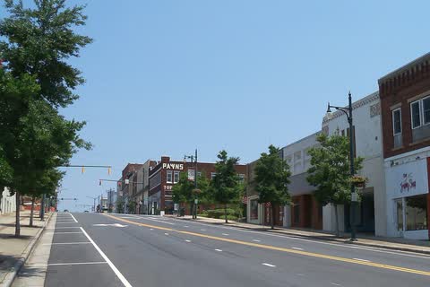 Wide downtown street in Albemarle lined with trees and brick storefronts