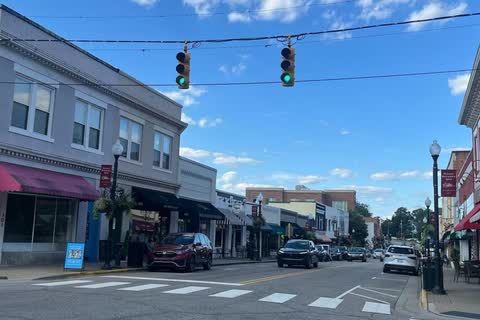 Two-story storefronts with awnings lining a street in downtown Apex