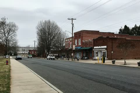 Street in Badin with a brick commercial building and a sidewalk