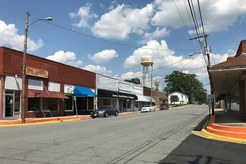 Storefronts along a street in Bailey, with the town water tower in the distance