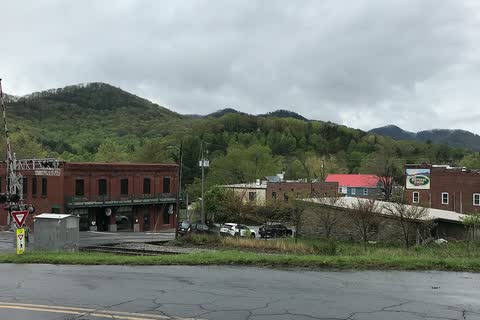 Low brick buildings of downtown Black Mountain with green mountain ridges behind