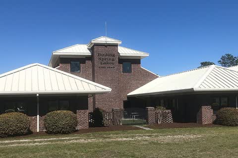 A brick municipal building with pale metal roofs in Boiling Spring Lakes