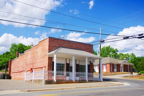 Single-story brick Bostic town hall with a white porch