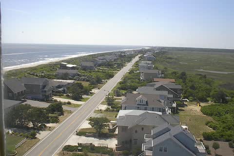 Looking west over houses, a road and the dunes beside the Atlantic Ocean at Caswell Beach
