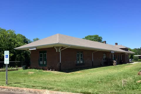 Single-story brick former railroad depot on a grassy lot in Cherryville