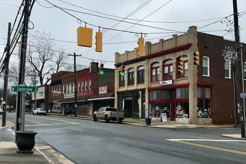 Two-story brick commercial building at a downtown China Grove intersection with traffic lights