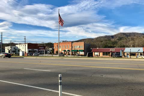 Low row of storefronts along Depot Street in Clyde with mountains behind