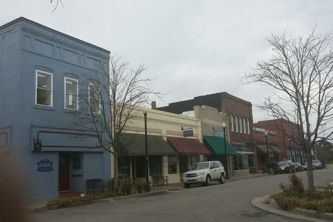 A blue two-story building and storefronts along Main Street in Columbia