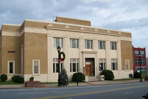 Tan stone Caldwell County Courthouse with a columned entrance in Lenoir