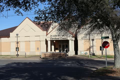 Front of the tan Cleveland County Courthouse with its entrance gables in Shelby