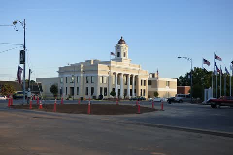 Cream-colored courthouse with a clock cupola across an open street