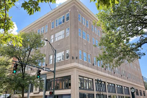 Tall historic office building on a tree-lined corner of Elm Street in Greensboro