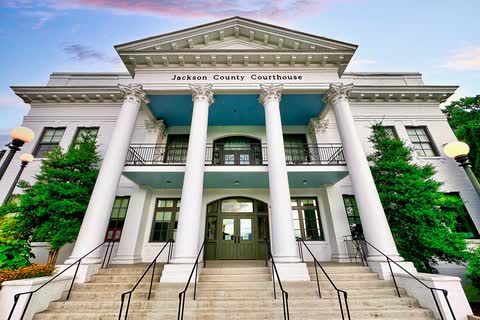 White columned historic Jackson County Courthouse with a long stone stair in Sylva