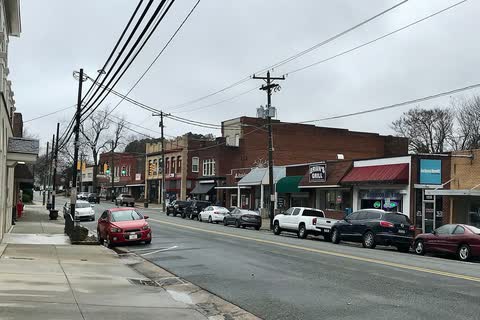 Brick storefronts and parked cars along Main Street in China Grove