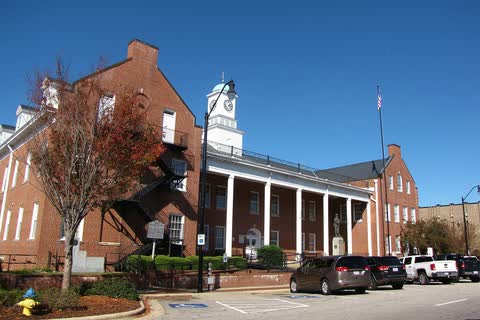 A red-brick courthouse with a white colonnade and clock cupola in Clinton, North Carolina