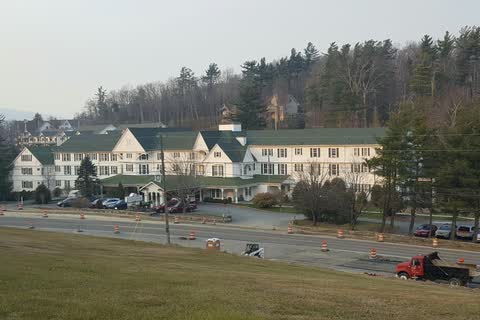 Long white historic hotel with green roofs on a hillside in Blowing Rock