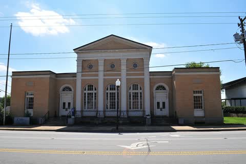 Tan brick neoclassical federal building with tall arched windows in Wilkesboro