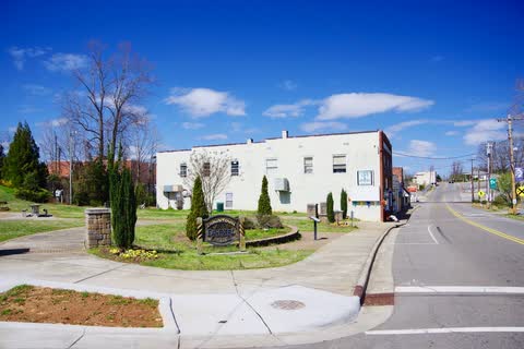Main Street in Drexel with a landscaped corner and a two-story white building