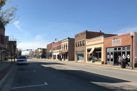 Two-story brick storefronts along a sunny street in downtown Dunn