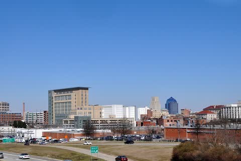 Downtown Durham's mix of historic and modern buildings under a clear blue sky