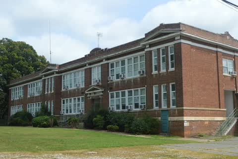 The East Spencer Graded School, a long two-story brick school building from the early 1900s on a lawn