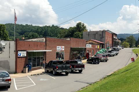 Brick commercial buildings and parked trucks along a street in Elk Park