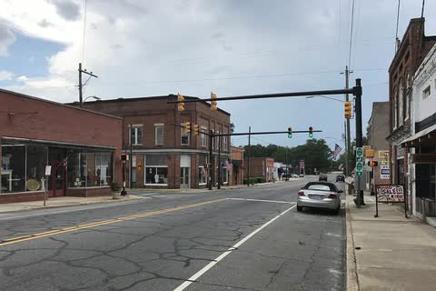 Street intersection in Ellerbe with brick storefronts and a traffic signal