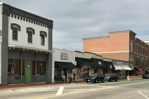 Downtown Elon street with a historic storefront and newer brick buildings