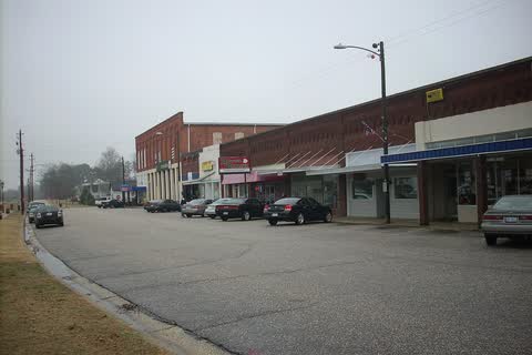 A row of brick storefronts along a curving street in Erwin
