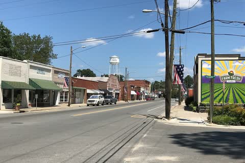 Storefronts along a street in Faison, with the town water tower in the distance