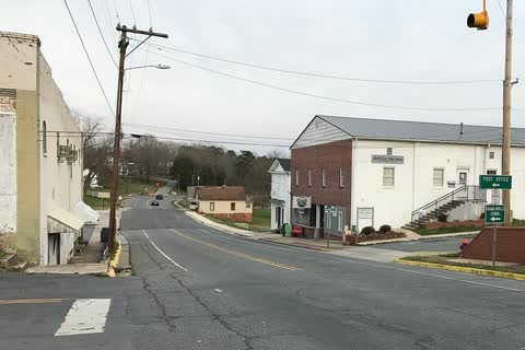 Road curving through Franklinville past a white two-story building