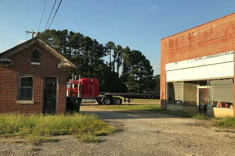 Two small brick buildings, one an old store, beside a lot in Garysburg