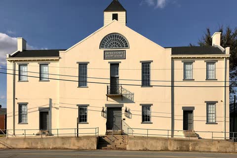 A two-story cream-colored historic courthouse with a small cupola in Gatesville