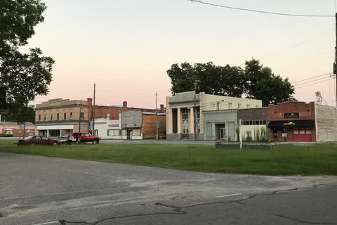 Low commercial buildings along Main Street in Gibson seen across an open lot