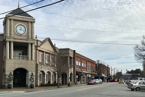 Main Street in Gibsonville with a clock tower building and a row of brick storefronts