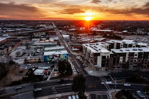 Aerial view of downtown Greenville's streets and buildings with the sun setting on the horizon