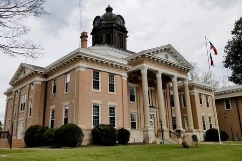 A tan-brick courthouse with a columned portico and a domed clock tower in Halifax