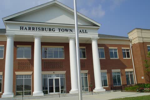 Brick town hall with tall white columns and a pediment reading Harrisburg Town Hall