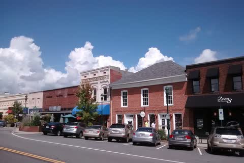 Brick storefronts and parked cars along Main Street in downtown Hendersonville