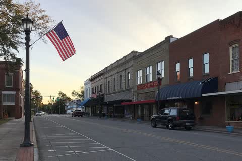 Brick storefronts and an American flag along a downtown street in Hertford