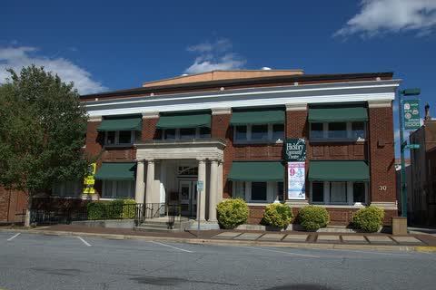 Two-story brick municipal building with green awnings in Hickory