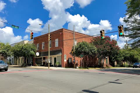 Brick commercial building at a corner on Churton Street in Hillsborough under a blue sky