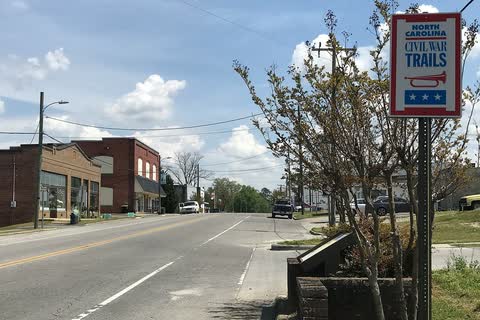 Brick commercial buildings along a street in Hookerton, with a Civil War Trails sign