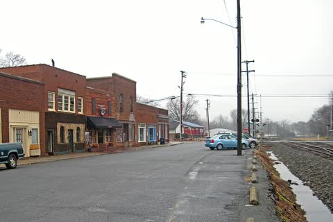 Row of older brick storefronts beside the railroad tracks in Huntersville