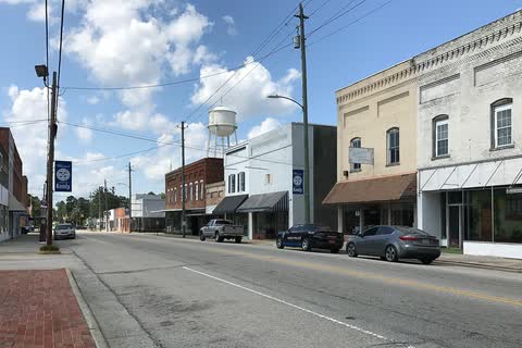 Storefronts along a downtown street in Kenly with the water tower in the distance