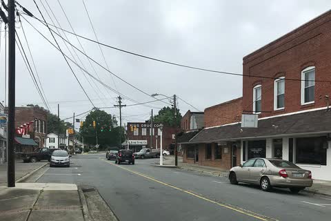 Main Street in King with a brick commercial building and parked cars on an overcast day