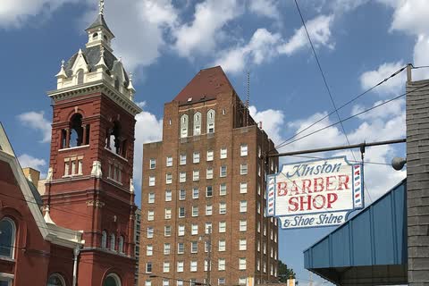 A red-brick church tower beside the tall brick Kinston Hotel in downtown Kinston