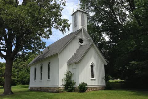 A small white wooden Gothic-style church among trees in Kittrell