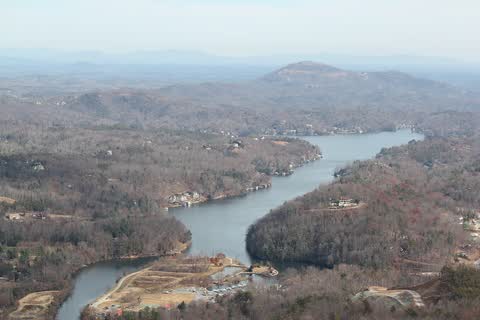 Lake Lure winding between forested hills, seen from above at Chimney Rock