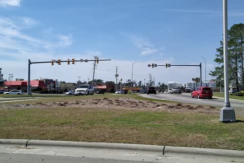 Village Road and its businesses seen from a highway off-ramp in Leland